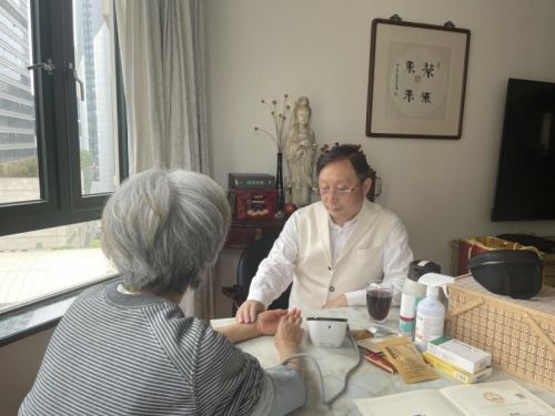 陈自明正在为患者进行把脉