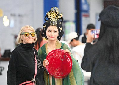 一名外籍遊客在天津國際郵輪母港客運大廳與演出人員合照。新華社記者 趙子碩攝