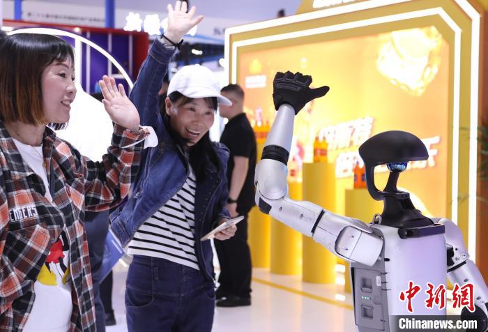 观众与人形机器人在第二十七届北京科博会上热情互动。记者 王紫儒 摄