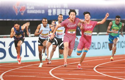 中國隊選手王勝傑(右二)和何錦櫶(右三)在4×100米接力資格賽比賽中交接棒。新華社記者 李明攝