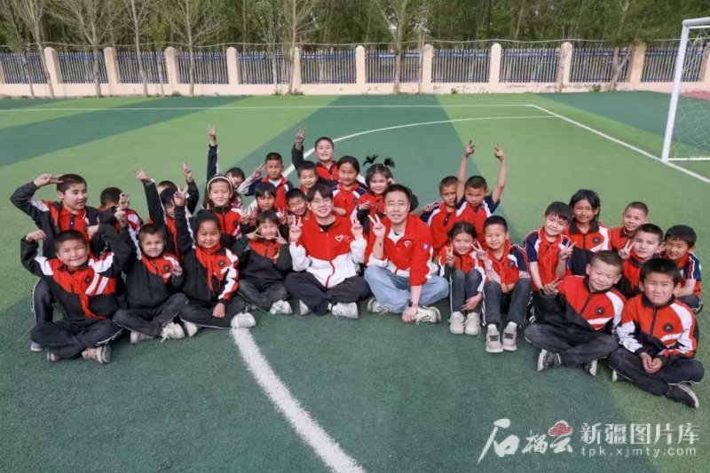 4月30日,誌願者李軻凡(前中右)、王俊文(前中左)與學生們在一起。謝依特小學供圖