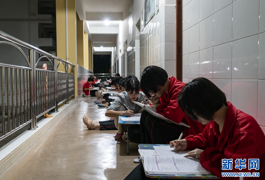 周雲麗在宿舍樓走廊輔導學生(資料圖)。(新華社 陳欣波 攝)