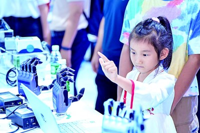     在第26届中国国际高新技术成果交易会深圳南山展区，观展儿童与“灵巧手”互动。资料图片