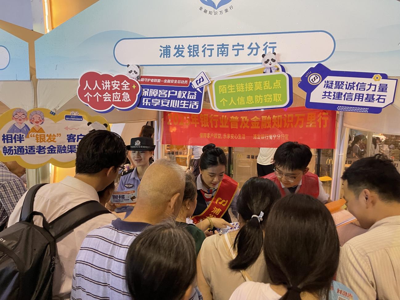 图为浦发银行南宁分行工作人员提醒银龄金融消费者“远离非法集资”