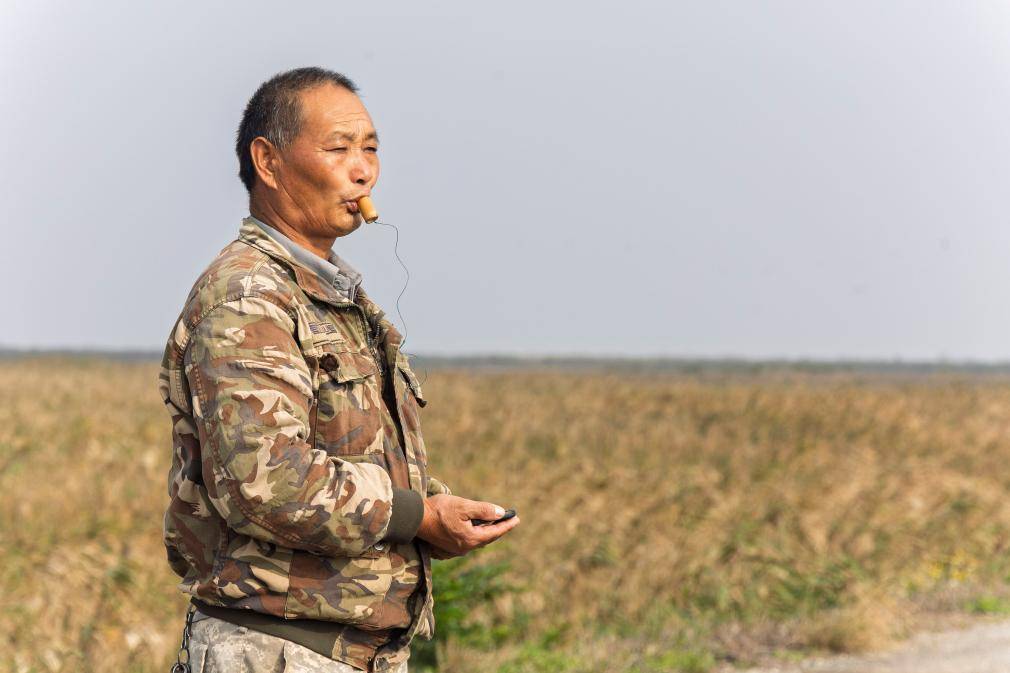 2024年11月12日,金偉國在上海崇明東灘鳥類國家級自然保護區吹鳥哨。新華社記者 王翔 攝