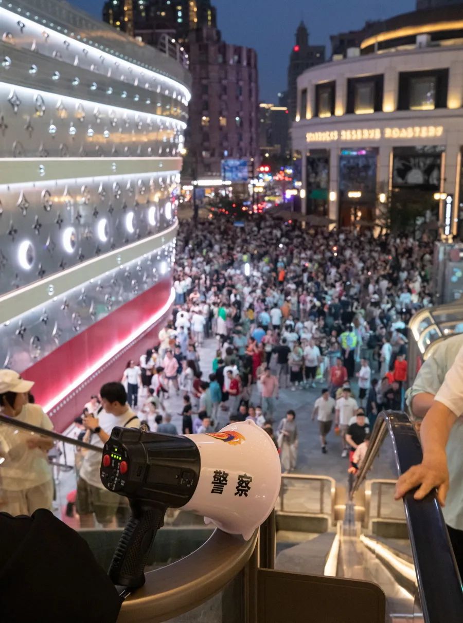 通往兴业太古汇的自动扶梯上方,一个警方喇叭反复提醒上行游客注意安全。图片来源:新民晚报