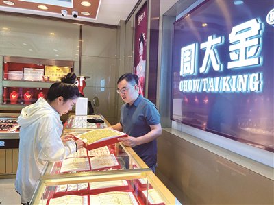 做二手奢侈品生意的谢祖平(右),接连开出多家金店。邓帆慧 摄