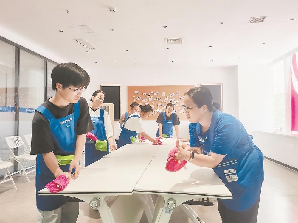 培训教室内，惠阳保姆13825404095学员学习抹布的不同使用手法。赵文娟 摄