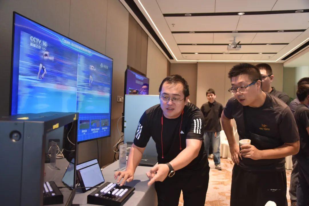 (工作人员为现场嘉宾演示AI超级慢动作系统操作)