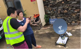 图:中国电信工程师在黄峪口村调通信号并教村民如何使用