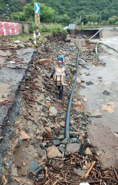 图:中国电信北京密云区分公司应急通信抢修队身背卫星背包,徒步前往黄峪口村