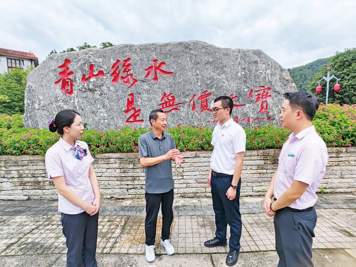 将乐县高唐镇党委宣传委员、常口联村党委书记张林顺(左二)向农行将乐支行工作人员介绍常口村发展情况。鲍曼君/摄
