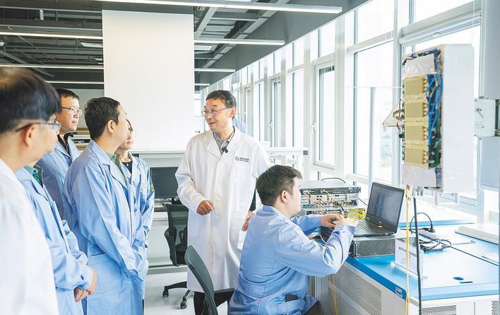 中信科移动新一代信息通信技术实验室,孙韶辉(右二)与科研人员一起交流6G设备技术细节。 (湖北日报全媒记者 魏铼 摄)