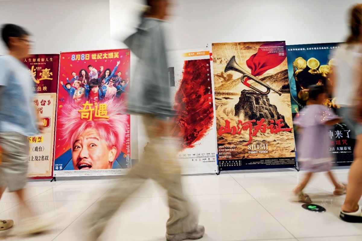 8月17日，山东青州一家影城的暑期档电影宣传海报前，观影人群陆续入场。本文图/视觉中国