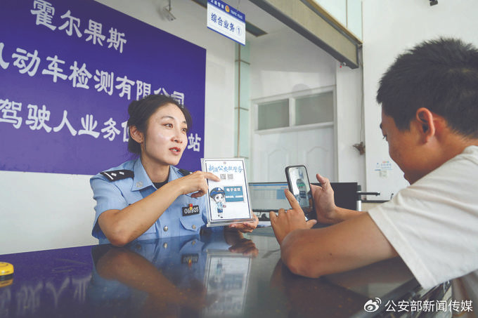 近日,新疆维吾尔自治区霍尔果斯市公安局车辆管理所民警指导群众使用新疆公安微警务小程序。宋印锐 摄