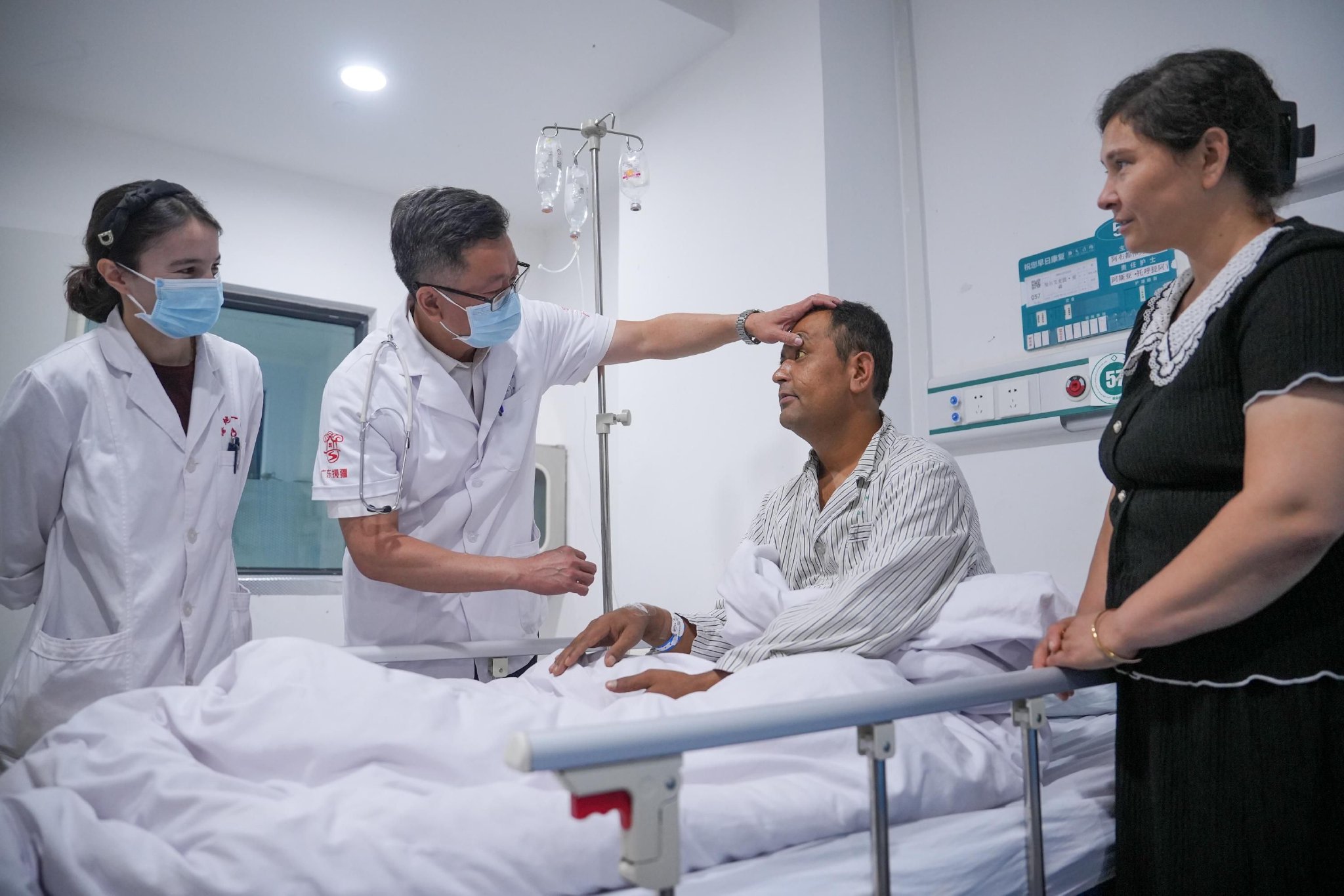 援疆医生张绍全带着库尔班妮萨为病人诊断病情。