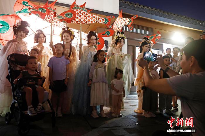 10月6日晚，中秋節，一場非遺魚燈巡遊在上海蟠龍天地上演。圖為孩子與身穿漢服的表演者合照。中新社記者 殷立勤 攝 