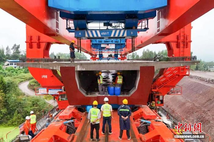 西渝高鐵謝家院子大橋上工作人員用架橋機架設箱梁。中鐵五局供圖