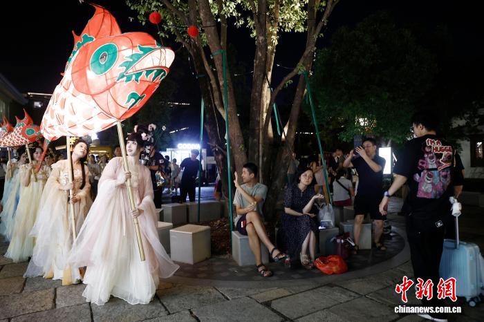 10月6日晚，中秋節，一場非遺魚燈巡遊在上海蟠龍天地上演。圖為民眾觀看巡遊。中新社記者 殷立勤 攝 