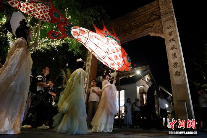10月6日晚，中秋節，一場非遺魚燈巡遊在上海蟠龍天地上演。圖為身穿漢服的表演者舉著魚燈巡遊。中新社記者 殷立勤 攝 