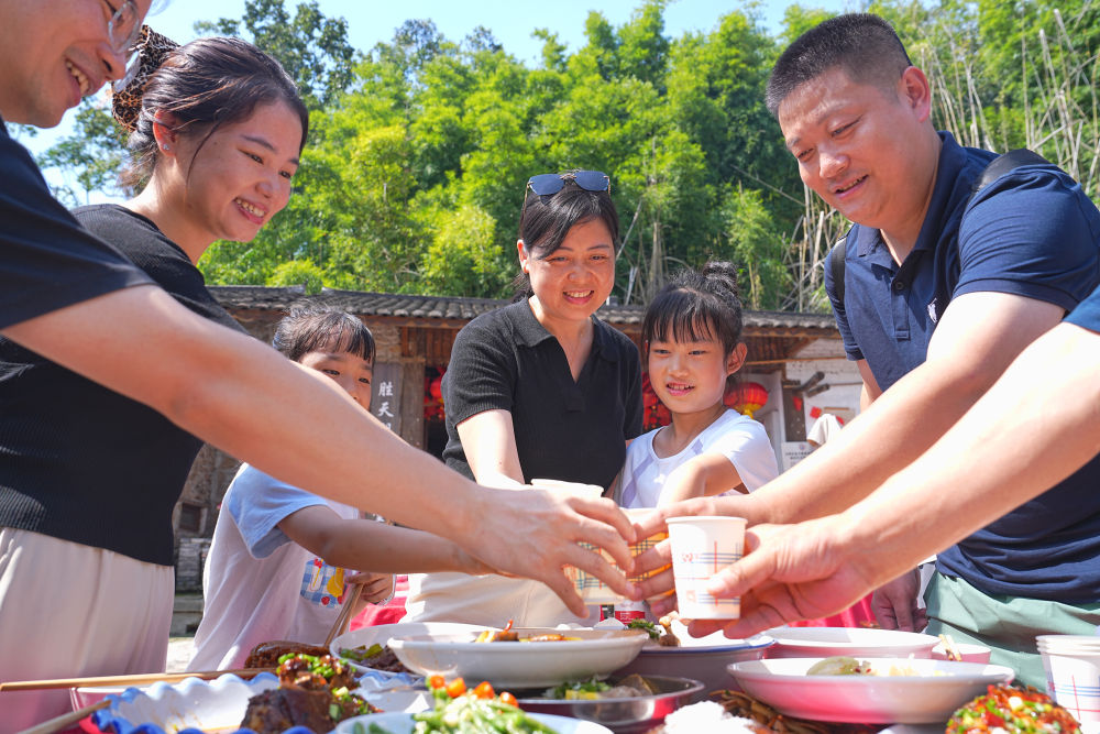 10月6日，在重庆市北碚区金刀峡镇胜天湖村“九斗碗坝坝席”现场，游客举杯共庆中秋佳节。新华社发（秦廷富摄）