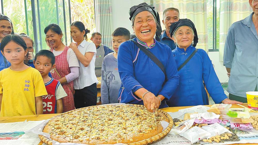 村民陸安秀在安置點為大家分發月餅。通訊員 楊素娟 攝