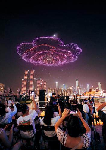 ▲10月1日，南岸區南濱路，人們正在觀看「新韻重慶 長安同行」無人機燈光秀表演。特約攝影 郭旭