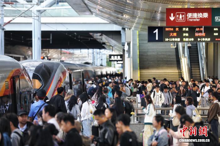 圖為國慶中秋假期旅客在昆明站搭乘動車出行。徐章位 攝