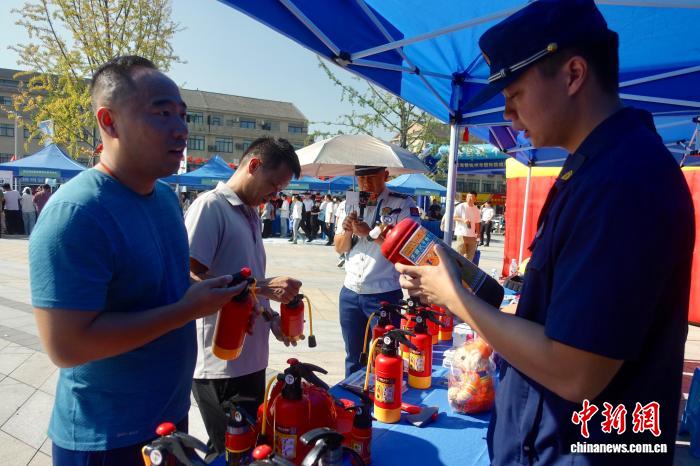 10月10日,消防員(右)向市民科普滅火器用法。中新社記者 錢晨菲 攝