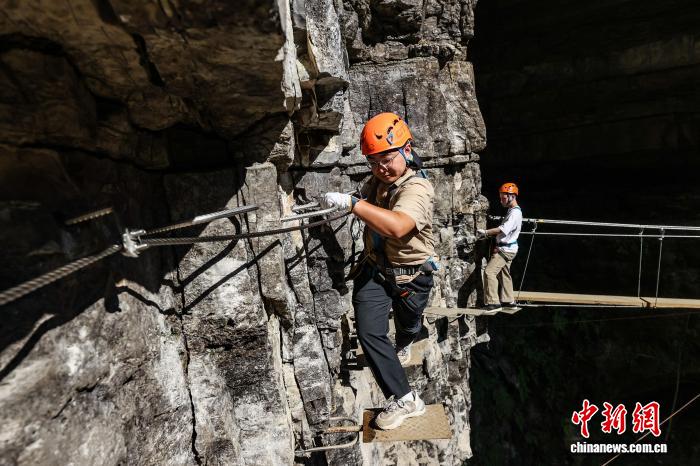 10月11日，遊客在貴州省遵義市綏陽縣雙河洞景區「懸崖之上·俠客咖啡」項目挑戰中。中新社記者 瞿宏倫 攝