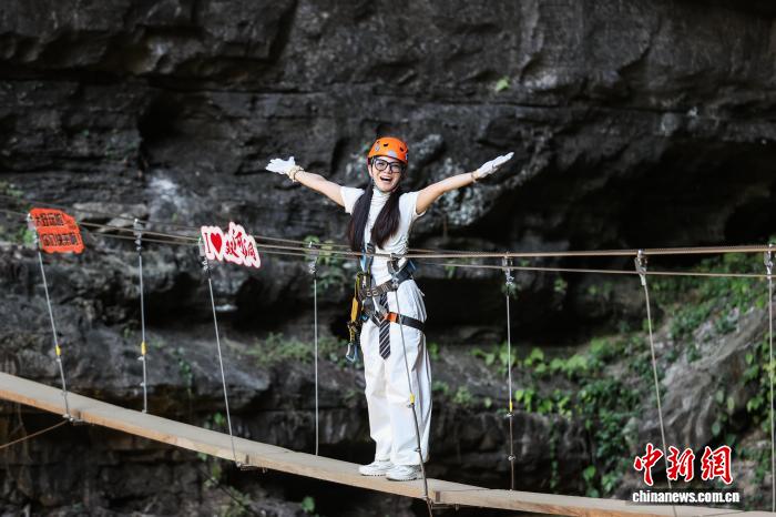 10月11日，遊客在貴州省遵義市綏陽縣雙河洞景區「懸崖之上·俠客咖啡」項目挑戰中。中新社記者 瞿宏倫 攝