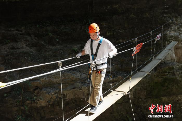 10月11日，遊客在貴州省遵義市綏陽縣雙河洞景區「懸崖之上·俠客咖啡」項目挑戰中。中新社記者 瞿宏倫 攝