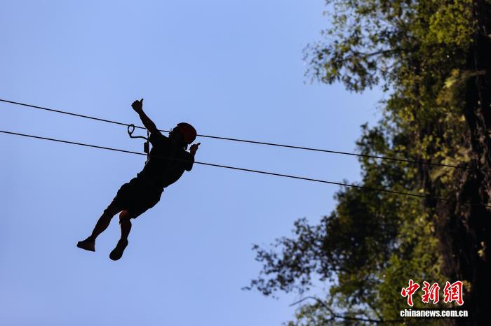 10月11日，遊客在貴州省遵義市綏陽縣雙河洞景區「懸崖之上·俠客咖啡」項目挑戰中。中新社記者 瞿宏倫 攝