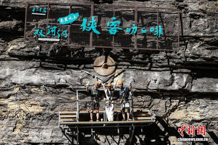 10月11日，遊客在貴州省遵義市綏陽縣雙河洞景區「懸崖之上·俠客咖啡」項目挑戰中合照。中新社記者 瞿宏倫 攝