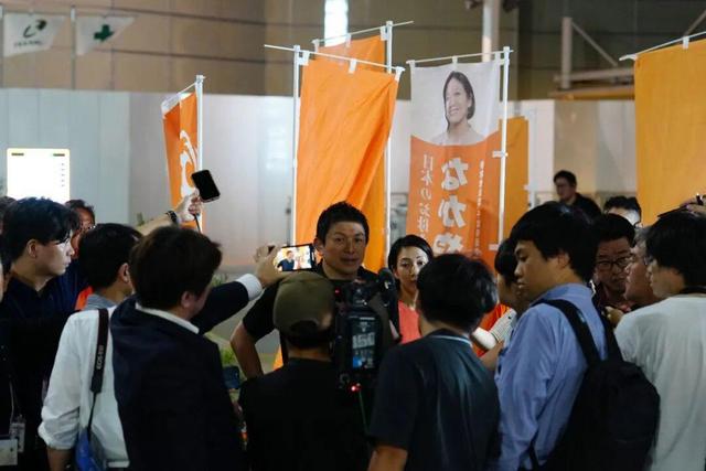 7月13日,在日本千叶县,参政党党首神谷宗币(中)在街头演说活动后接受媒体采访。新华社记者贾浩成摄