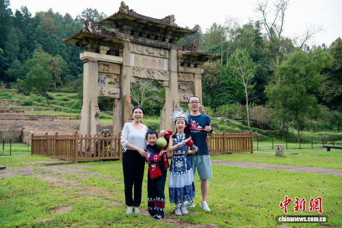 遊客在唐崖土司城址「荊南雄鎮」牌坊前拍照打卡。吳洋 攝