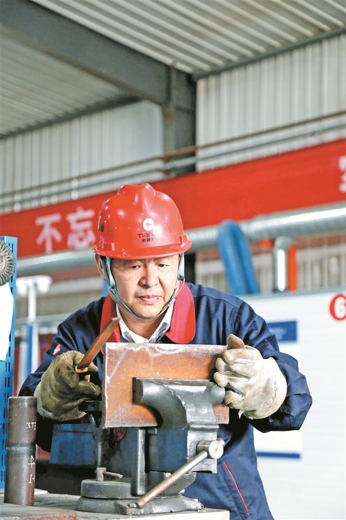 中新建电力集团所属新疆天富伟业工程有限责任公司物资部部长、副总工程师杨建立在焊接(资料图片)。
