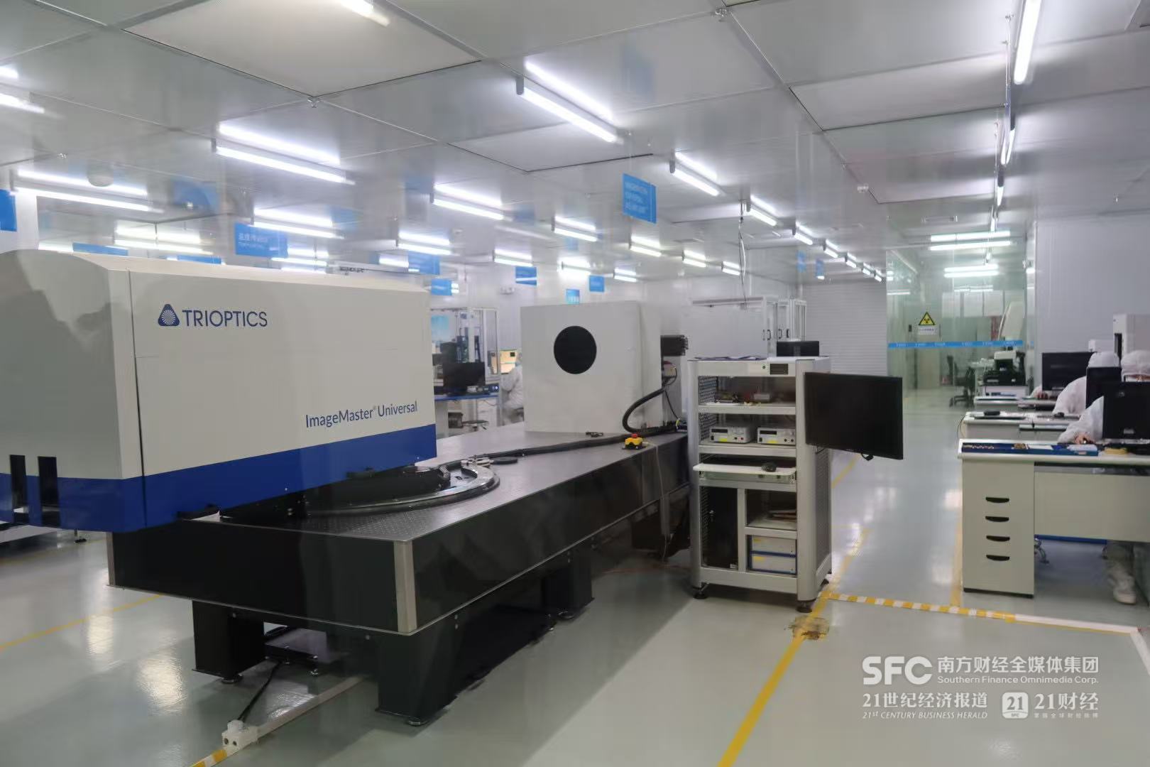 (精密实验室内的生产机器和工作人员。 本报记者 梁信/摄)