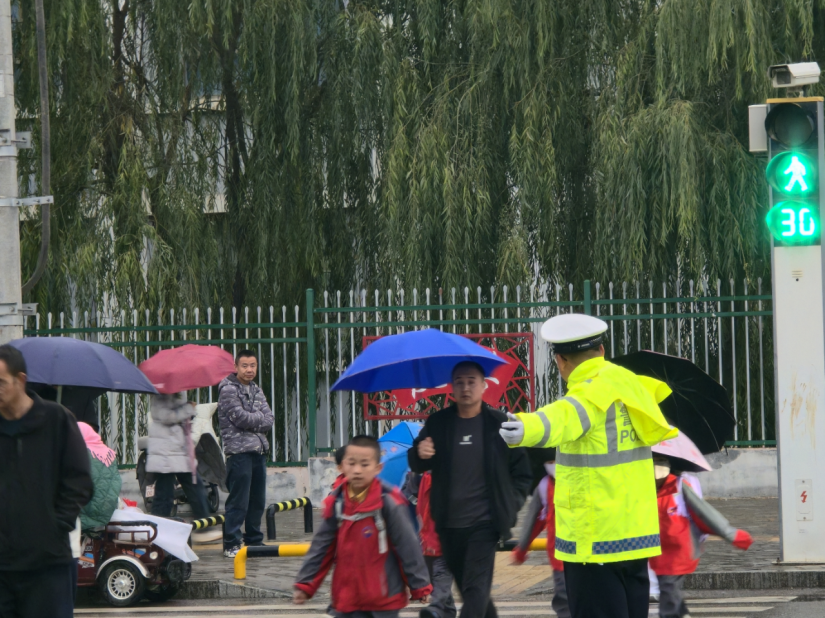 10月16日下午放学时分，古浪县公安局交警大队城关中队民辅警在县城道路疏导指挥过往车辆，站好“护学岗”。王晓君/摄