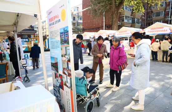 居民正在活动现场咨询家政服务的相关产品