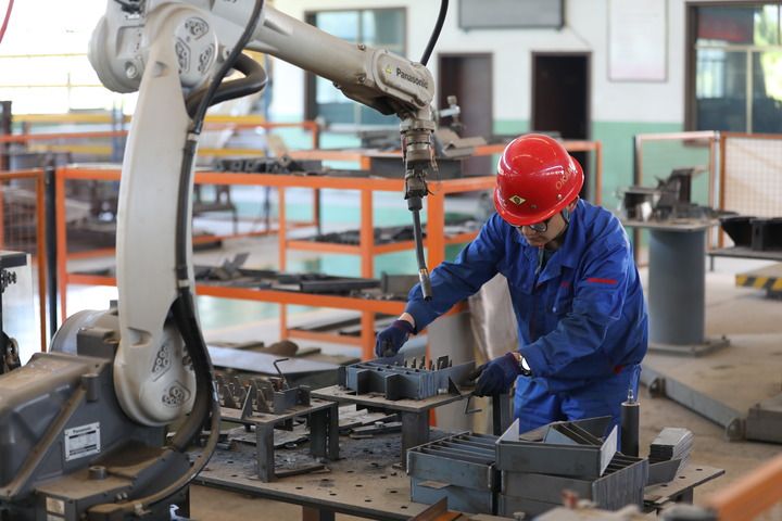 　　8月21日，酒泉奥凯种子机械股份有限公司的工人正在焊接机器人的辅助下作业。新华社记者 张智敏 摄