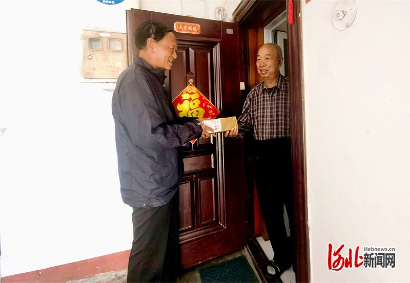 10月17日,韩有名(左)到李增家送快递。河北日报记者 孙也达摄