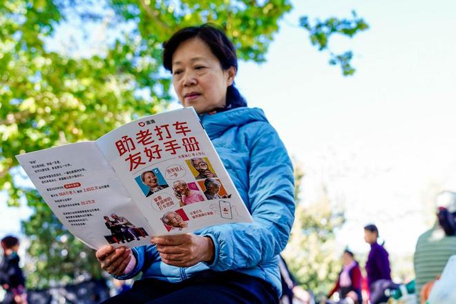 图为：严阿姨正在阅读助老打车友好手册