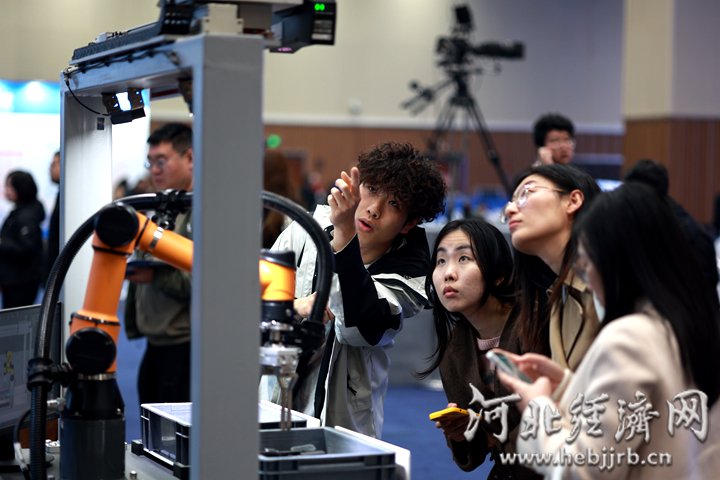 与会人员在梅卡曼德（雄安）机器人科技股份有限公司展台前，了解配备了高精度工业3D相机的机器人。河北经济日报记者 袁立朋 摄