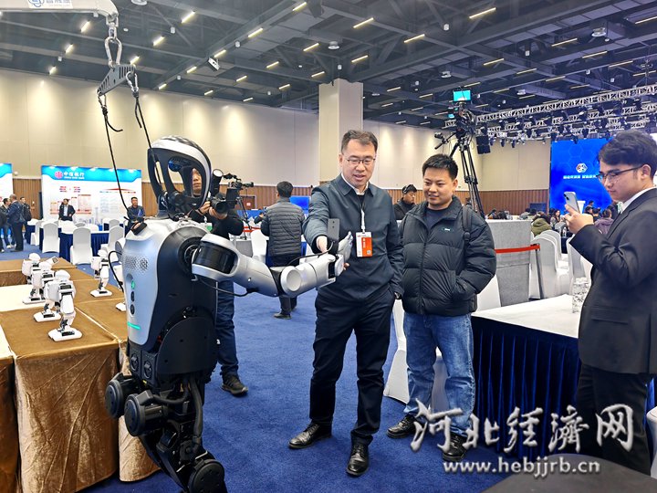 与会人员与展出的机器人握手。河北经济日报记者 袁立朋 摄