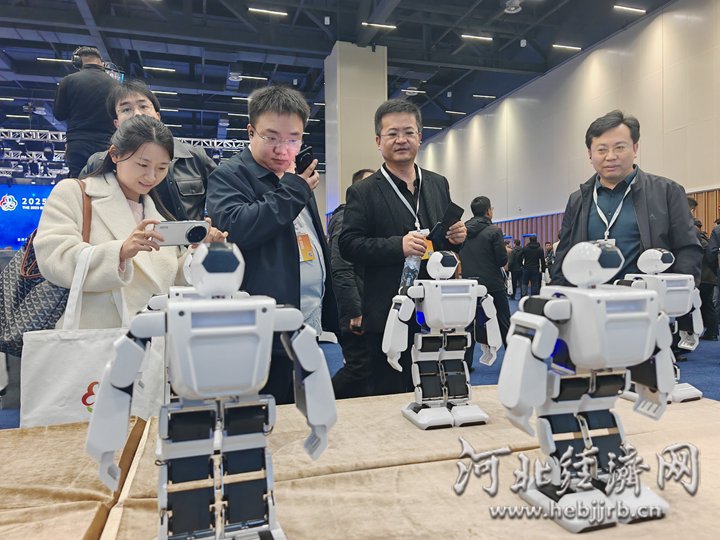 与会人员观看现场展出的小型机器人。河北经济日报记者 袁立朋 摄
