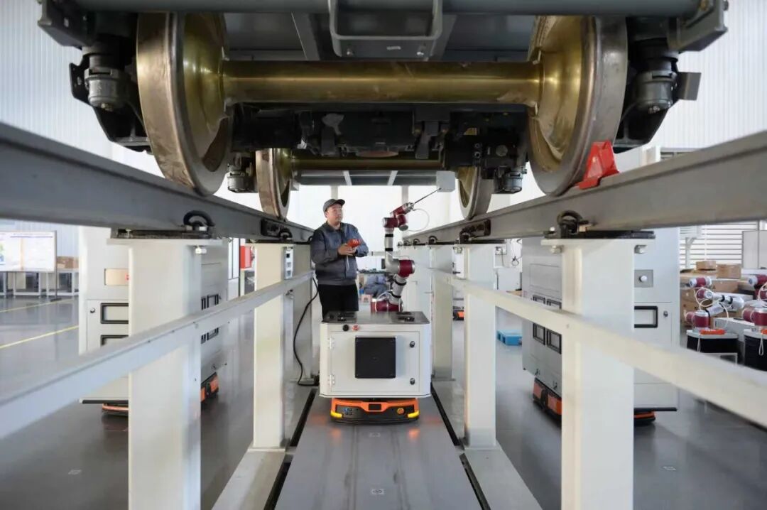 唐山百川机器人共享制造工厂内技术工人正在调试车底吹扫机器人 图/吕泽宣摄