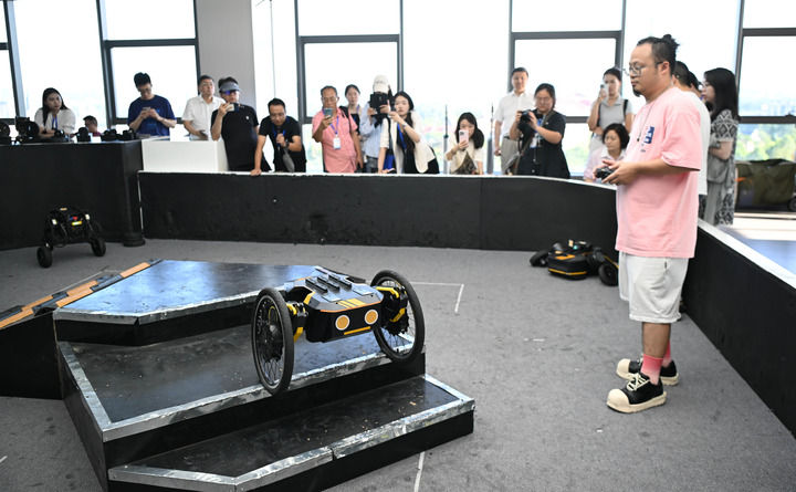  2025年6月23日，在广东东莞松山湖XbotPark机器人基地，本末科技工作人员操作机器人爬楼梯。新华社记者 邓华 摄