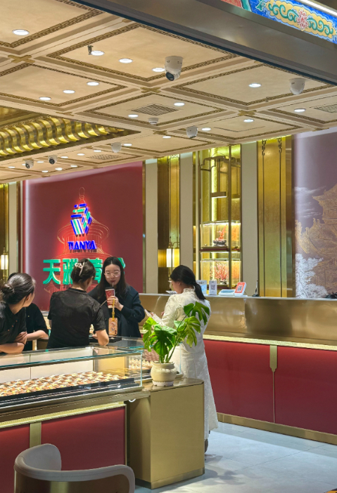 10月28日，在北京市天雅珠宝城某品牌柜台，顾客正在挑选黄金饰品。新华网记者 闫雨昕 摄