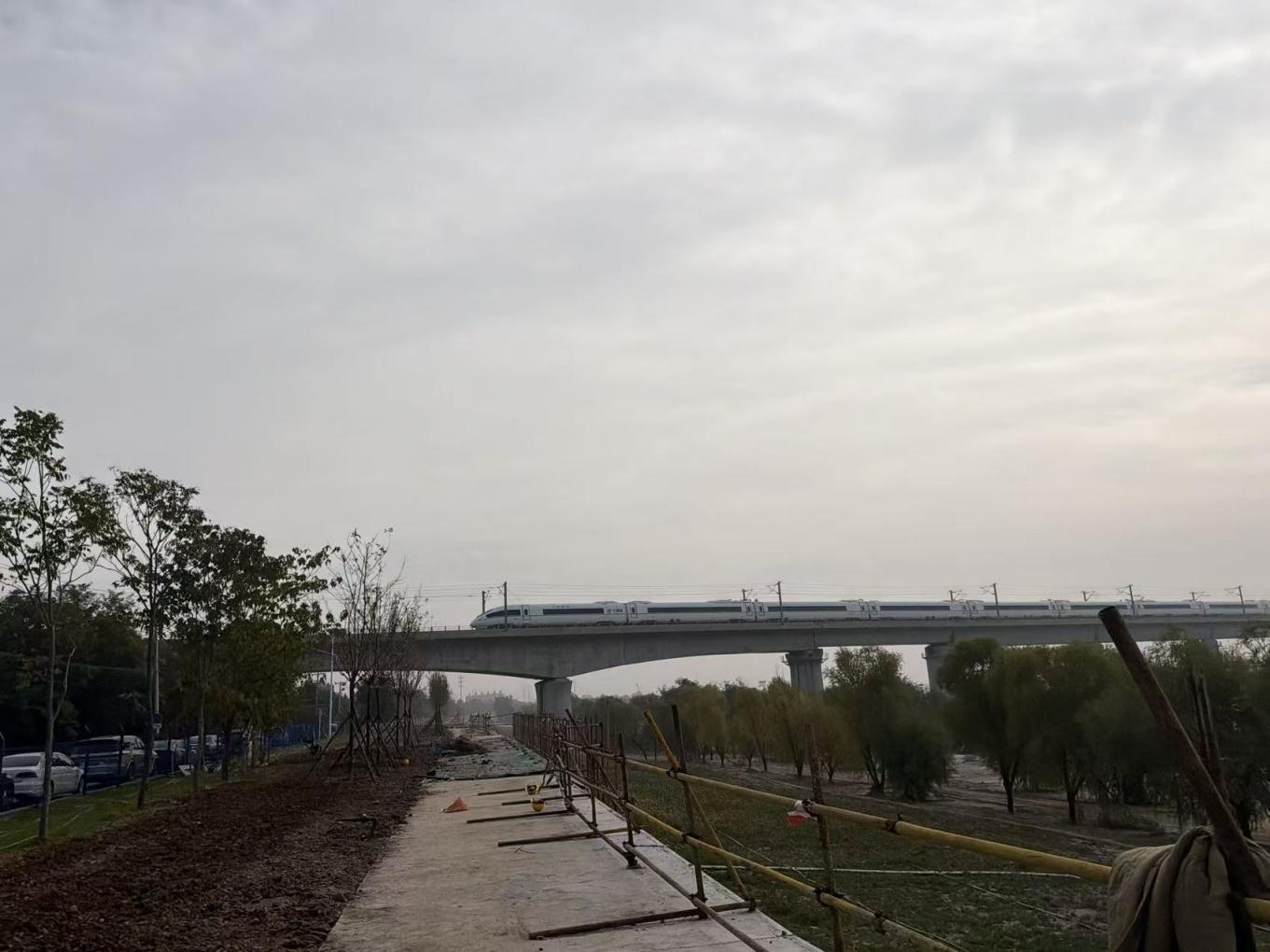 站在永定河左岸堤防堤顶，可以拍到疾驰而过的高铁列车